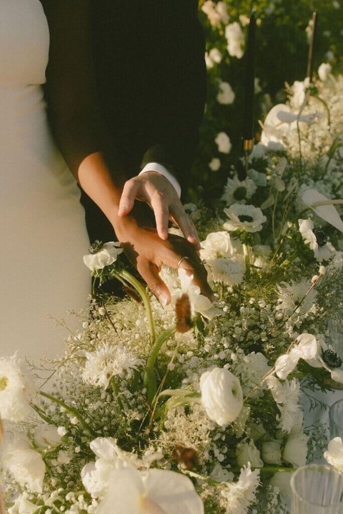 couple de mariés qui touchent la décoration de mariage